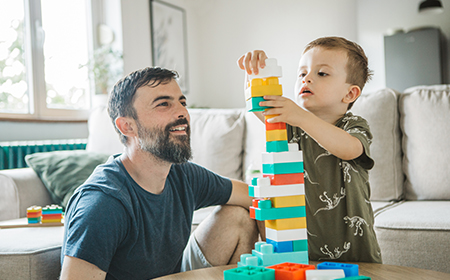 father and child playing with building blocks